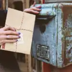 Getting Legal Mail for Someone Else—a woman holding an envelop near an old post box