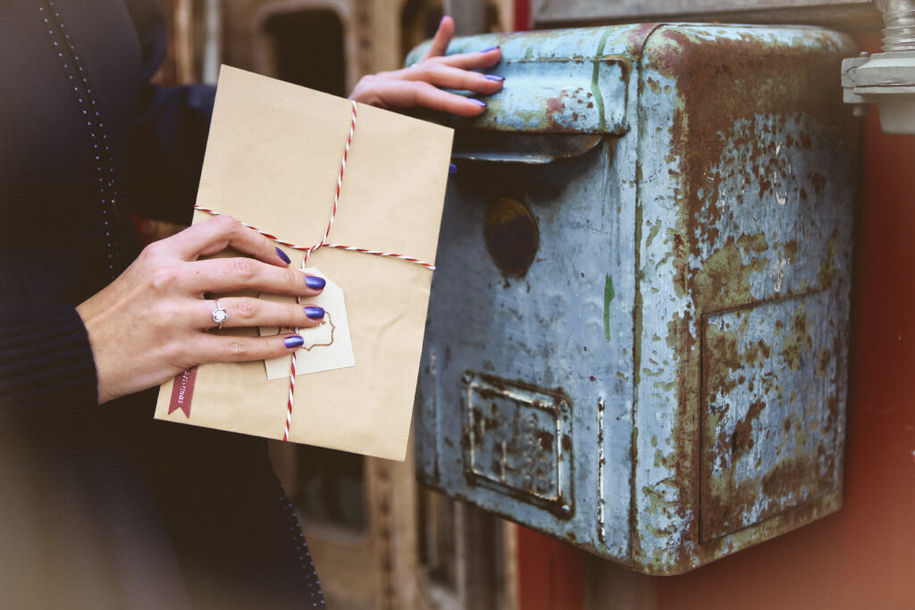 Getting Legal Mail for Someone Else—a woman holding an envelop near an old post box