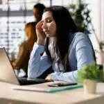 A woman at her desk worried about registered agent delays.