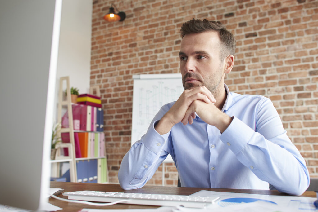 A man at his desk thinking if sole proprietorships and registered agents are relevant.