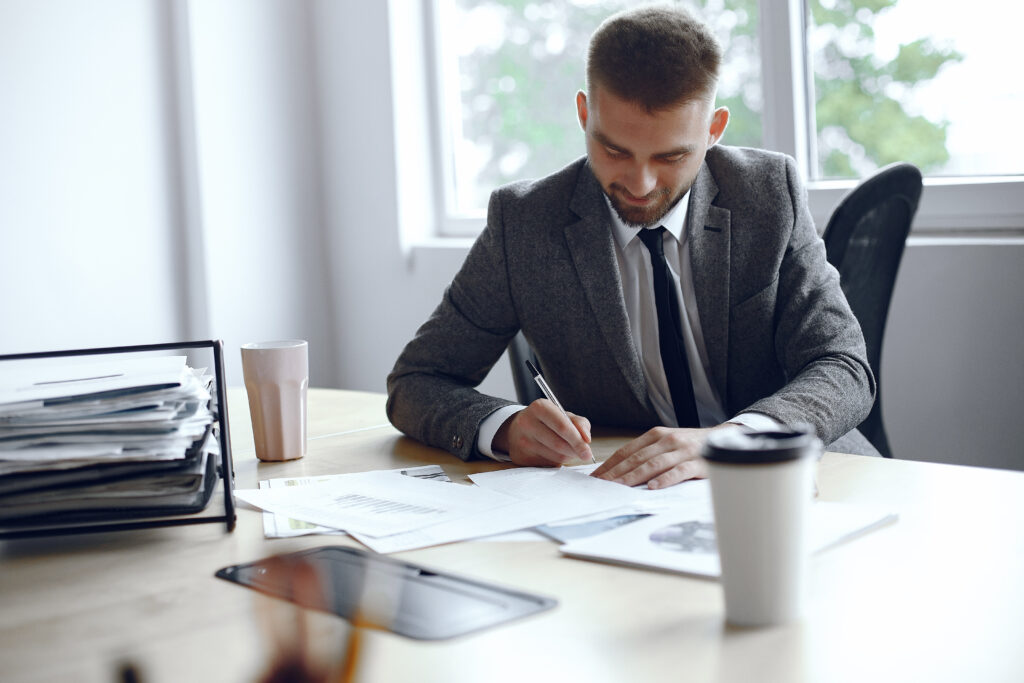 A male virtual registered agent sitting at office desk.