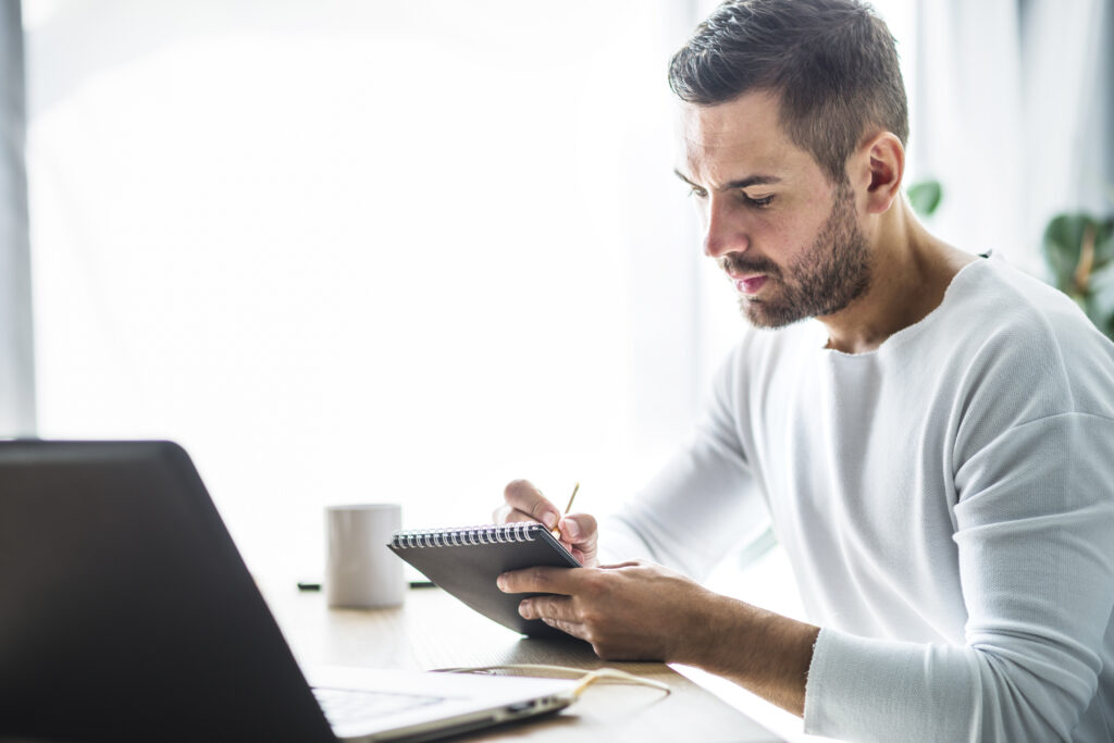 A man at his desk reviewing his end-of-year checklist.